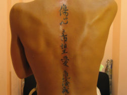 Художественная татуировка вдоль позвоночника. Японские иероглифы
