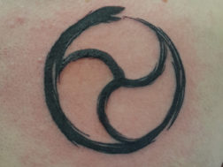 Татуировка - Стилизованная змея кусает себя за хвост