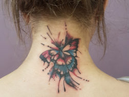 Цветная бабочка на шее девушки