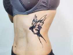 татуировка на рёбрах стилизованная ласточка сразу после нанесения