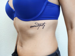 Татуировка на ребрах, надпись в виде каллиграфии